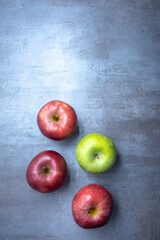 red and green apples on a gray stone background. View from the top. Free space