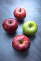 red and green apples on a gray stone background. View from the top. Free space