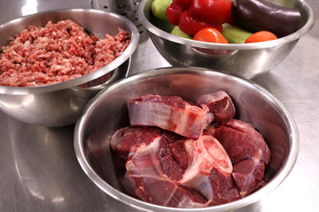 Food products for cooking. Minced meat vegetables and pieces of fresh meat in a metal bowl.