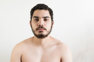 Fototapeta premium Caucasian young man with brown eyes and beard, naked torso and shaved chest.