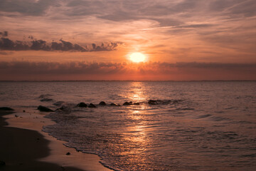colorful sunset with waves at the beach