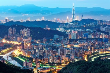 Aerial panorama of overpopulated suburban communities in Taipei at dusk with view of Taipei 101 Tower in downtown & bridges over Xindian River ~ A romantic evening of Taipei in beautiful blue twilight