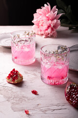 Two glasses of pink pomegranate lemonade on a white table