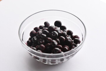 Superfood, vegan ingredients photographed on a high-key background, include bananas, blueberries, kale, soy milk, flaxseed milk, peanut butter, pumpkin seeds and salt.