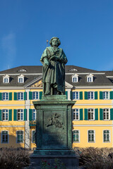 Obraz premium statue of famous composer Ludwig van Beethoven - with the beautiful Old Post Office building in the background, located on Munsterplatz in the city of Bonn in Germany.
