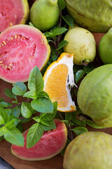 sliced and whole guava and tangerine fruits with Basil leaves