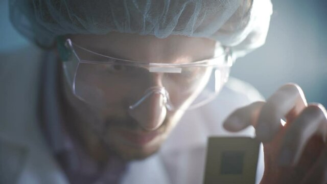 CPU in hands of a technician. Processor is being examined for apparent defects.