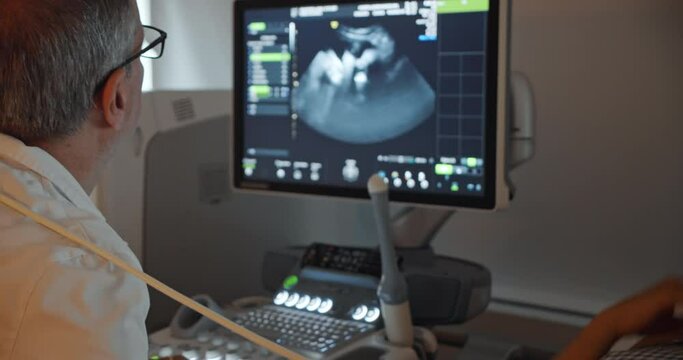 Doctor doing 3d ultrasound on belly in clinic. Process of fetus ultrasonography. Pregnancy and Healthcare concept