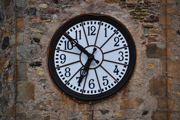 Fototapeta na wymiar Background, round clock with a light dial on a stone wall