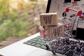 Shopping online concept - Parcel or Paper cartons with a shopping cart logo in a trolley on a...