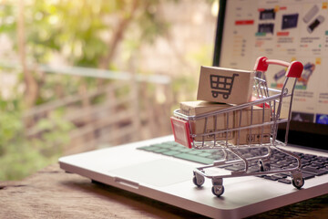 Shopping online concept - Parcel or Paper cartons with a shopping cart logo in a trolley on a...