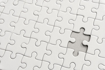 White jigsaw puzzle pattern background. placing last piece of jigsaw puzzle.