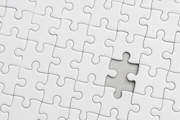 White jigsaw puzzle pattern background. placing last piece of jigsaw puzzle.