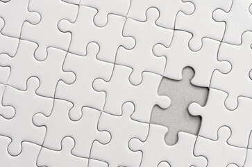 White jigsaw puzzle pattern background. placing last piece of jigsaw puzzle.