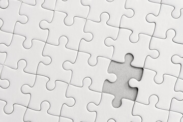 White jigsaw puzzle pattern background. placing last piece of jigsaw puzzle.