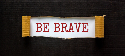 The words 'be brave' appearing behind torn black paper. Beautiful background. Business concept.