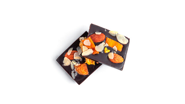 Raw chocolate bar with dried fruits and nuts on a white background. High quality photo