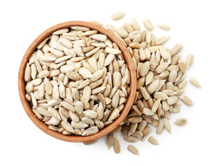 Sunflower kernels in a wooden plate and scattered on a white background. Top view.