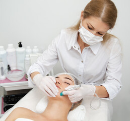 Woman getting ultrasound face beauty treatment in medical spa center.