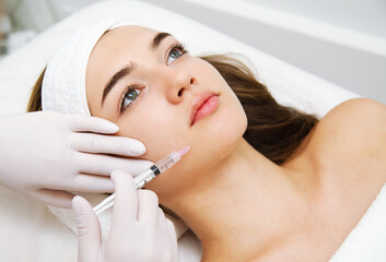 Woman getting cosmetic. injection. Beauty injections and cosmetology.  Young woman in beauty salon sloseup. - 393631375