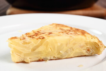 Piece of Spanish omelette on plate. Macro.