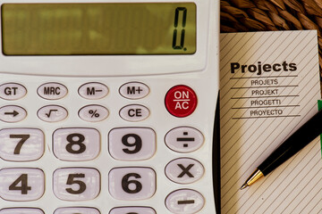 Una calculadora junto a una hoja de proyecto y un bolígrafo. - obrazy, fototapety, plakaty