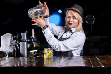 Girl bartender creates a cocktail on the brasserie