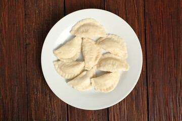 Cooked Dumplings on plate at wooden plank background. Directly Above.