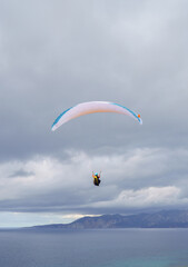 Paragliding flying over the sea in the mountains in southern Sardinia

