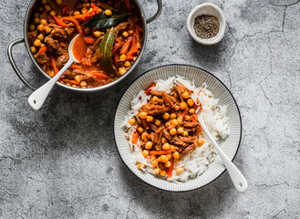 Slow cooker beef stew with chickpeas and rice on a grey background, top view