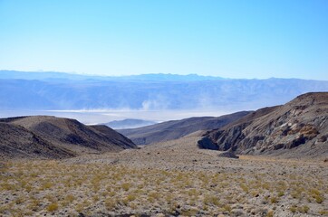 Death Valley landscape in California, view from Highway 190, dust on horizon, blue sky background
