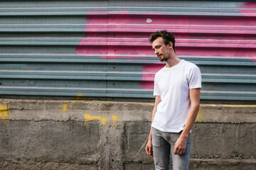 Young bearded hipster guy wearing white blank t-shirt. Mock-up for print. T-shirt template.