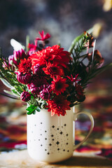 Bouquet de fleurs d'automne avec des dahlias et chrysanthèmes couleur rose et rouge dans un pot en décoration sur la table 