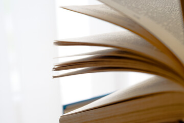 Open book, hardback books on bright colorful background.