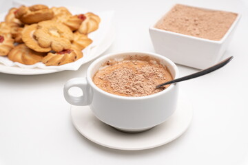 Cup of cocoa with lumps with pastes and cocoa powder on white background