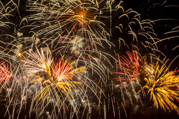 Fireworks display against the night sky. Flying sparks, colorful colored smoke. Holiday vivid background