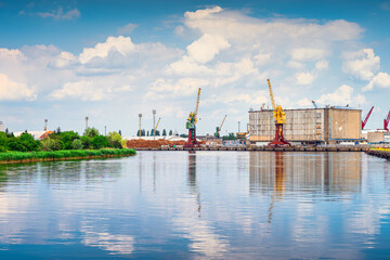 Cargo, industrial port and harbour in Szczecin with stacks of timer, tall dock cranes and industrial machinery. West Pomeranian, Poland