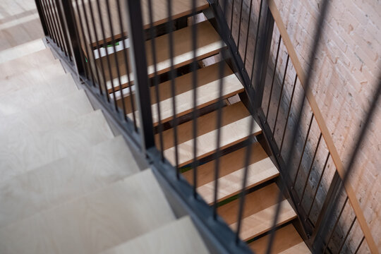 Staircase with wooden steps and metal railing. Modern design stairs in restored industrial building.