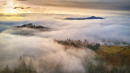 Cold November morning. Morning fog in mountain valley. Forest covered by low clouds.