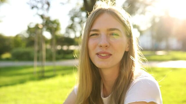  young woman smiling and looking in the park, street portrait of a smiling girl, happy cheerful girl laughing in the park