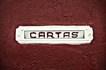 Letter box woth Spanish word 'cartas' (in English: letters), white on brown background.