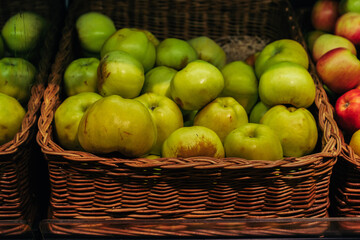 basket with fresh green apples in grocery store. Image with selective focus