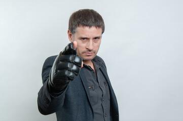 Naklejka premium Photo of a serious man with black boxing glove pointing at camera