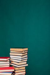 stacks of books for education in the university library on the green background of the place for the inscription