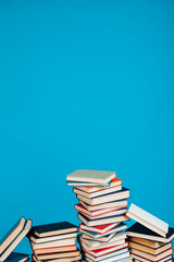stacks of books for education in the college library on a blue background place for inscription
