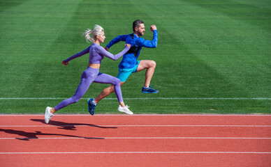 Fototapeta premium athletic couple of sprinters run on running track at stadium, energy