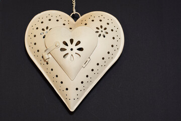 Decorative white metal heart with ornaments on the chain. Vintage Hanging Heart Decoration.