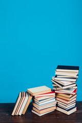 stacks of books for education in the college library on a blue background place for inscription