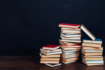 stacks of books for education in the library on a black background place for inscription