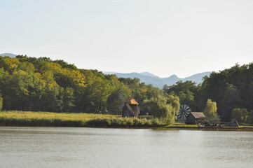 Landscape with lake, forest and windmills in the background